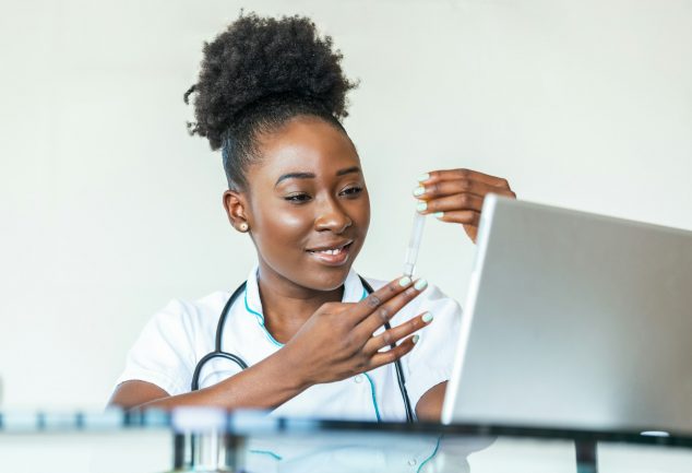 Black doctor in front of computer speaking